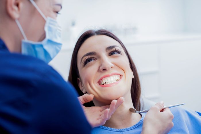 Woman with big perfect smile sitting in chair during dental visit worn teeth dentist in Annapolis Maryland